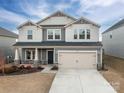 Charming two-story home featuring a two-car garage, stone accents, and manicured landscaping at 1038 Amberley Crossing Dr, Belmont, NC 28012