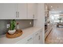 Bright kitchen features white cabinets, gray backsplash, and quartz countertops at 1049 Kinship Dr # 77, Lancaster, SC 29720