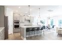 Bright, open kitchen features an island with bar seating, pendant lighting, stainless steel appliances and dining area at 1055 Kinship Dr # 78, Lancaster, SC 29720