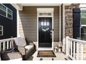 Inviting front porch featuring comfortable seating, a charming welcome mat, and decorative lanterns at 11440 Westbranch Pkwy, Davidson, NC 28036