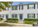 Charming townhouse with a well-maintained lawn, complemented by classic shutters and a welcoming front door at 140 Reid Ln, Pineville, NC 28134