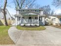 Classic white two-story home with a cozy front porch featuring a swing and a well-manicured front yard at 2028 Scott Ave, Charlotte, NC 28203