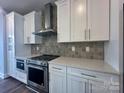 Close up of the modern kitchen's stainless steel oven, countertops, and sleek white cabinetry at 2035 Clarksdale Dr # 33, Charlotte, NC 28206