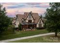 Expansive rear of home features covered porch overlooking the beautifully landscaped yard at 314 Royal Crescent Ln, Waxhaw, NC 28173