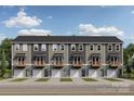 View of new townhome exteriors featuring modern design with attached single car garages and small front yards at 550 Beatties Ford Rd, Charlotte, NC 28216