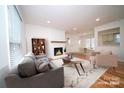 Inviting living room with fireplace, neutral tones, and ample natural light from large windows at 5925 Carmel Station Ave, Charlotte, NC 28226