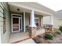 Inviting front porch with decorative stone pillars, seating, and a charming welcome to the home at 822 Wisteria Way, Salisbury, NC 28146