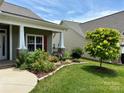 Exterior home view showcasing a well-manicured lawn and colorful flower beds enhancing the property's curb appeal at 822 Wisteria Way, Salisbury, NC 28146