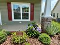 Close-up of a garden bed with flowering bushes in front of the house, along with a community sign at 822 Wisteria Way, Salisbury, NC 28146
