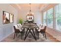 Bright dining room featuring modern chandelier, hardwood floors, and large windows that bring in natural light at 1012 Equipoise Dr, Indian Trail, NC 28079