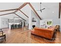 Open-concept living room featuring vaulted ceilings, exposed beams, brick fireplace and hardwood flooring at 1131 Doby Ct, Fort Mill, SC 29715