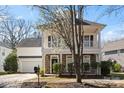 Charming two-story home featuring a double porch, stone accents, and a manicured front yard at 13014 Windy Lea Ln, Huntersville, NC 28078