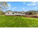 Expansive backyard with a wooden deck and pergola, perfect for outdoor entertaining at 1335 Blacksnake Rd, Stanley, NC 28164