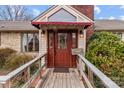 Inviting front entrance with a wooden ramp leading to the red door and awning above at 136 Coble Ave, Albemarle, NC 28001