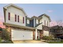 Charming two-story home boasts a stone facade, neutral siding, red shutters, and a spacious two-car garage at 15119 Oleander Dr, Charlotte, NC 28278