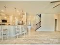 Open-concept interior featuring a breakfast bar, stainless steel appliances, and wood-look floors at 15119 Oleander Dr, Charlotte, NC 28278