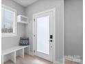 Bright entryway featuring a bench, decorative pillow, modern door, and natural light at 206 Freeland Ln, Charlotte, NC 28217