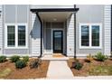 Welcoming entryway with a modern door, manicured landscaping, and a paved walkway leading to the entrance at 210 Freeland Ln, Charlotte, NC 28217