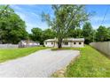 Inviting single-level home with a neutral exterior, a gravel driveway, and mature trees offering plenty of shade at 228 Tot Dellinger Rd, Cherryville, NC 28021