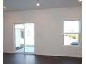 Bright living room with dark wood floors, a sliding glass door, and a large window at 3511 Nimbell Rd, Monroe, NC 28110