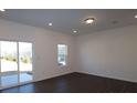 Bright living room with dark wood floors, a sliding glass door, and a large window at 3511 Nimbell Rd, Monroe, NC 28110