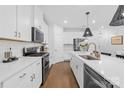 Updated kitchen featuring stainless steel appliances, white cabinets, and quartz countertops at 3512 Auburn Curb Rd, Charlotte, NC 28217