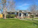 Inviting home with tidy front yard, mature shrubs, and a charming front porch, creating a warm and welcoming atmosphere at 4201 Winedale Ln, Charlotte, NC 28205
