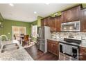 Spacious kitchen features stainless steel appliances, granite countertops, mosaic backsplash, and dark wood cabinets at 6211 Canyon Trl, Denver, NC 28037