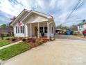 Well-maintained home with a classic front porch, surrounded by lush landscaping and a concrete driveway at 719 Washington St, Cramerton, NC 28032