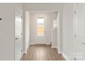 Bright entryway with wood-look flooring, a glass-paneled front door, and staircase at 107 Adams Tree Way, Troutman, NC 28166