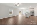 Open-concept living space with wood-look floors, ample natural light, and an island kitchen at 107 Adams Tree Way, Troutman, NC 28166