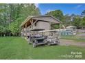 Exterior view showcasing a covered RV and golf carts parked on a lush green lawn, offering a glimpse of leisure and convenience at 109 Pembrooke Trl # F171, Mount Gilead, NC 27306
