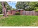 Nice backyard view of a red brick home with a wooden fence and green grass at 1125 Mcdow Dr, Rock Hill, SC 29732