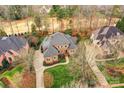 An aerial view of a beautiful brick home features lush landscaping and a circular driveway at 11311 Mcclure Manor Dr, Charlotte, NC 28277