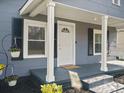Cozy front porch featuring a white front door, porch swing, and blooming flowers at 125 Ashe St, Gastonia, NC 28056