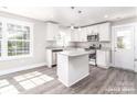 Modern kitchen featuring white cabinets, stainless steel appliances, and a center island at 1308 Jay Ave, Gastonia, NC 28052