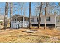 Charming manufactured home with a cozy porch and landscaped front yard for relaxed outdoor living at 140 Sanford Ln, Badin Lake, NC 28127
