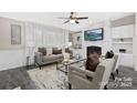 Stylish living room with a fireplace, built-in shelves, and large windows, creating a bright, inviting space at 140 Sanford Ln, New London, NC 28127