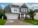 Inviting two-story home showcases a manicured lawn and a welcoming covered front porch at 16725 Cozy Cove Rd, Charlotte, NC 28278