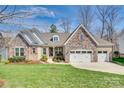 Beautifully landscaped exterior elevation of a brick and stone home, showcasing a well-maintained lawn and curb appeal at 17927 Culross Ln, Charlotte, NC 28278