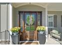 Close-up of the front door adorned with a wreath and flanked by potted flowers at 190 Hidden Meadows Dr, Mooresville, NC 28117