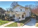 Angled view of a charming white two-story home with brick walkway, stone wall and manicured front yard at 2004 Lombardy Cir, Charlotte, NC 28203