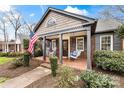 Inviting front porch with rocking chairs, porch swing, brick floor, and stylish columns at 2009 Charlotte Dr, Charlotte, NC 28203
