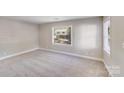 Sunlit bedroom with fresh paint, neutral carpet, and large windows offering pleasant outdoor views at 2328 Edison St, Charlotte, NC 28206