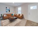 Cozy living room featuring a leather sofa set, area rug, and sunlit window at 239 Damask Dr, Lancaster, SC 29720
