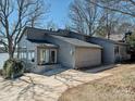 Well-maintained single-story house with a neutral exterior, mature trees, and a concrete driveway at 3030 Point Clear Dr, Tega Cay, SC 29708