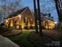 Charming brick home featuring manicured landscaping and a welcoming, illuminated entrance at 341 Beckwick Ln, Concord, NC 28025