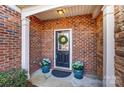 Inviting front entryway featuring a wreath-adorned door, blue planters, and brick accents at 4224 Park South Station Blvd, Charlotte, NC 28210