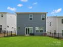 View of the home's back exterior, with a well-maintained lawn and full sliding glass door at 518 Palmarosa St, Fort Mill, SC 29715