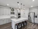 Modern kitchen features an island with seating, stainless steel appliances, and pendant lighting at 518 Palmarosa St, Fort Mill, SC 29715